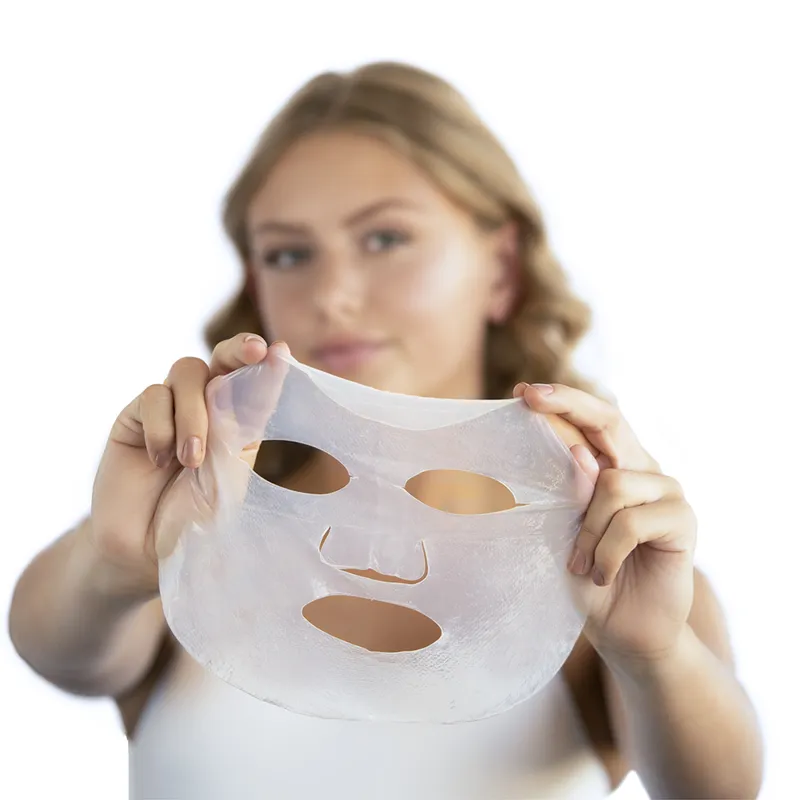 Frau hält eine transparente Gesichtsmaske vor ihr Gesicht.