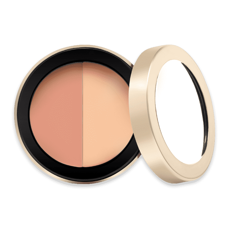 Zweifarbiger Concealer in runder, goldener Dose mit Spiegel, geöffnet.